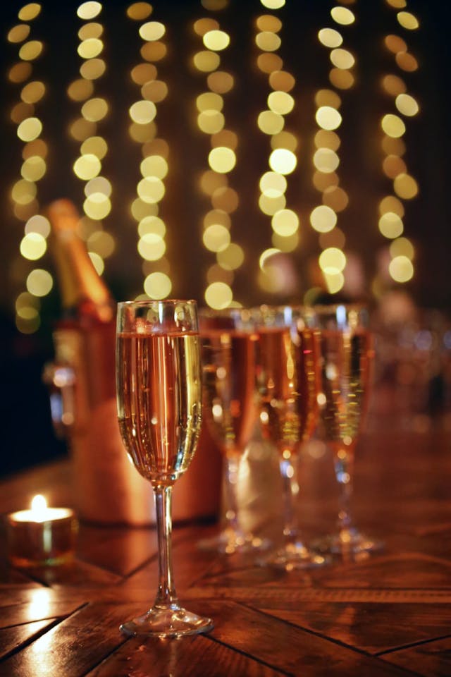 Champagne flutes with blurred fairy lights in the background